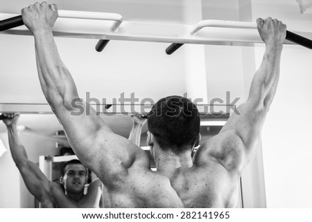 Muscular man working out with weights in gym.Man working out in a fitness club. Very power athletic guy bodybuilder