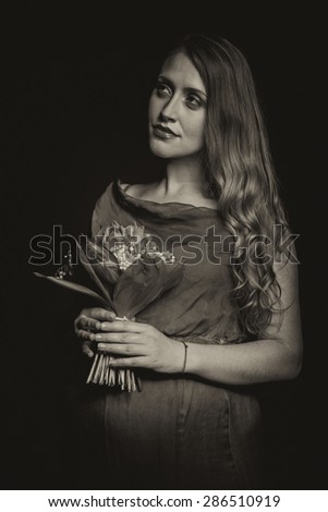 Beautiful pregnant woman on a black background. Art photography, sepia treatment. Pregnancy, waiting child.