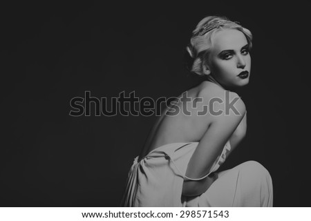 Portrait of a gorgeous blonde in a low key. The mystery, sadness, insecurity, human emotions. The girl in the style of the 20s.