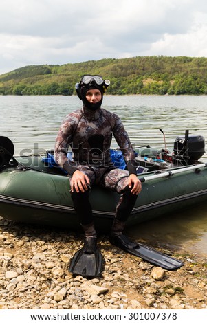 The guy in a diving suit. Diving, diving in the river. Suit for spearfishing. Spearfishing.