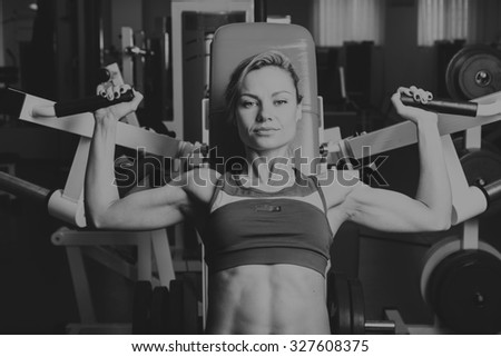 Girl pumps the major muscle groups in the gym. Strength training. Female fitness. Strong girl.