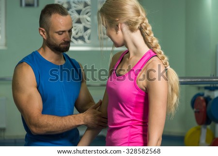 Young couple in the gym. Mutual support and assistance in the exercises. Work on your body. Photos for sporting and social magazines and websites.