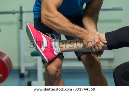 Young beautiful girl takes exercises with a trainer. Training in the gym. Proper exercise. Photos for sporting magazines and websites.