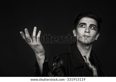 Professional game young actor. Black and white photo on a dark background. Professional makeup and theatrical image. Photo for cultural and fashion magazines and websites.