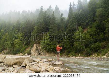 Fishing in the beautiful mountain river. Trout fishing in the mountains. Exciting fishing and beautiful scenery. Photos for natural and fishing magazines, posters and websites.