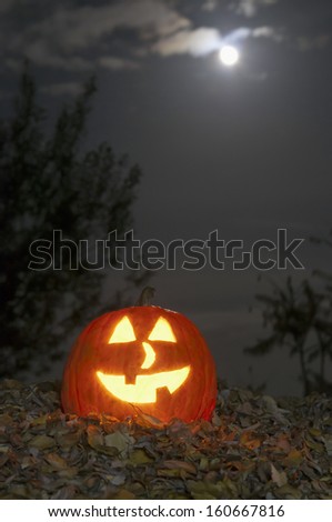 Long time exposure Halloween candlelight pumpkin by night with moon