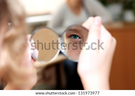 reflection of a green eye in a small mirror