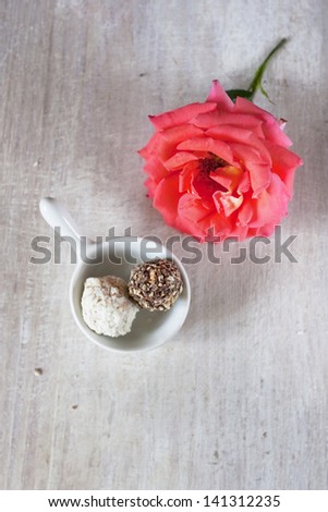 Two candy on the ghina gravy boat and rose, top view