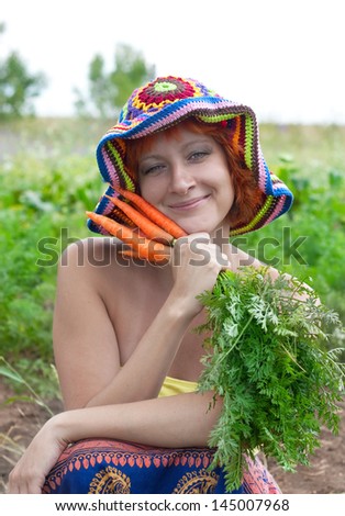 red-haired woman in the crocheted hat with bunch of carrots