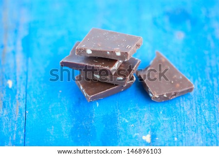 pieces of milk chocolate on bars in the blue wood board