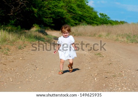 small smile child in the white dress come along the dirt road