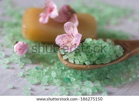 aromatic salt aqua water bath on a wooden spoon, organic soap and flowers
