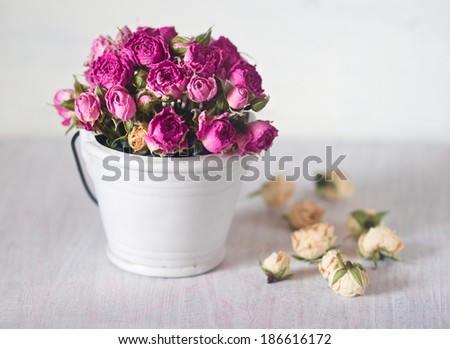 beautiful bouquet of pink roses in a decorative small white bucket