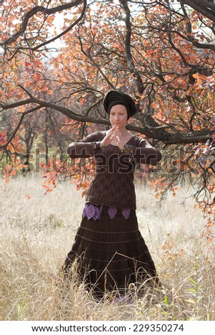 Young woman dancing the sacred dance in the beautiful autumn forest