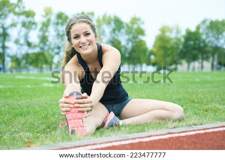 Stretching leg young woman jogging track