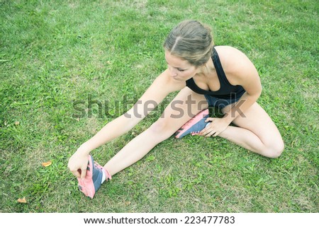 Stretching young woman grass