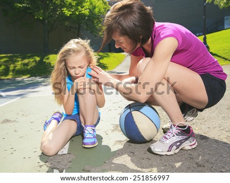 A mother play basketball with his daughter how have injury