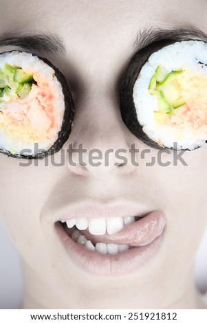 Funny picture of woman with sushi roll on her eye. Isolated on white background.