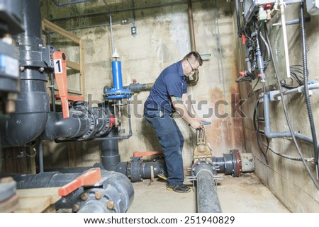 repairman engineer of fire engineering system or heating system open the valve equipment in a boiler house