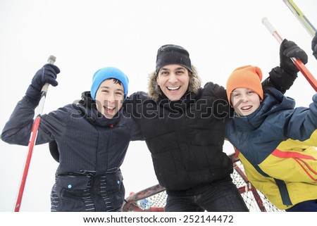 A family playing at the skating rink in winter.