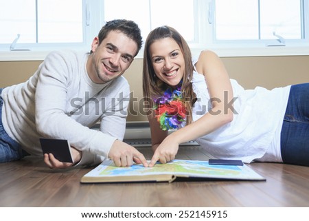 A Cheerful couple looking at a MAP in the living room