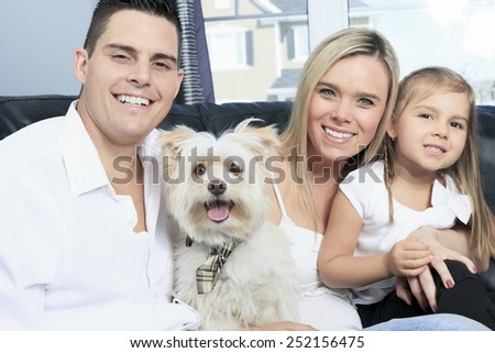 A Family with pets sit on sofa at home