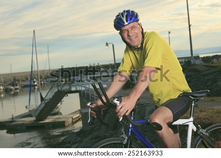 A senior man on bike at the sunset.