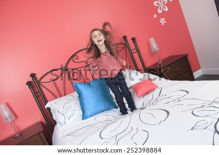 A Beautiful little girl jump on bed