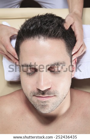 Man receiving Shiatsu massage from a professional masseur at spa salon