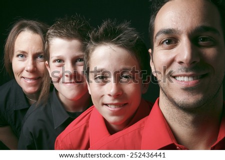 family portrait of four siblings in front of black background