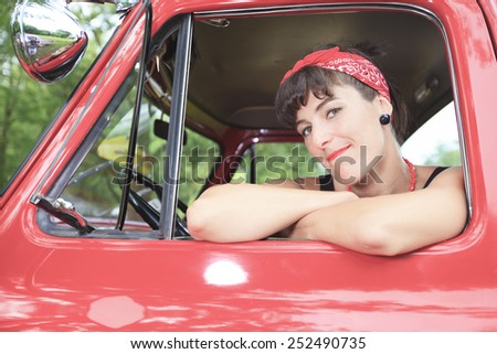 A retro girl with a beautiful red old car.