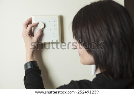 A woman in house who set is thermostat.