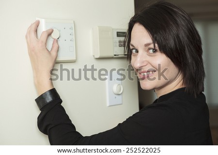 A woman in house who set is thermostat.