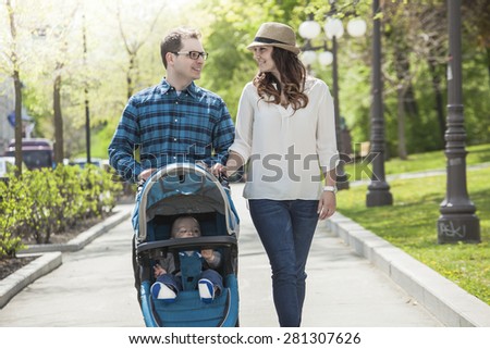 young family with baby strollers on city walk