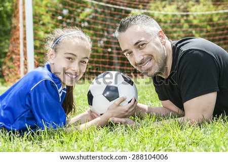 teenager girl with father play soccer