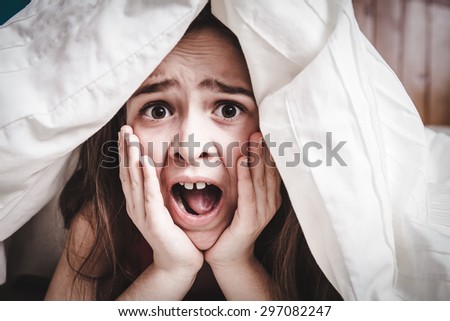 This white Caucasian young teenage girl hides under his blankets and covers
