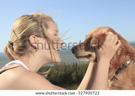 Teenage girl plays with the dog outside. The dog give his foot.
