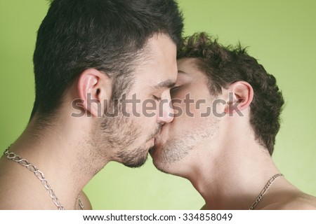 A gay couple on the bed giving kiss.