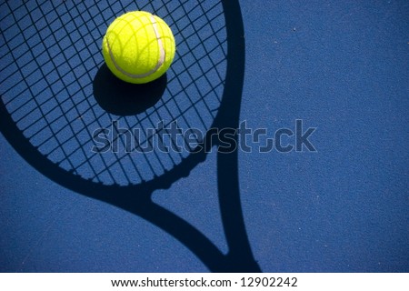 A bright tennis ball in a racket shadow with copyspace on the right