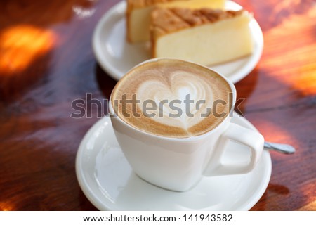 Cup of latte coffee with cake