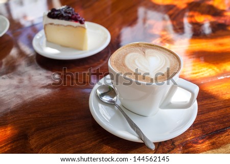 Cup of latte coffee with cake