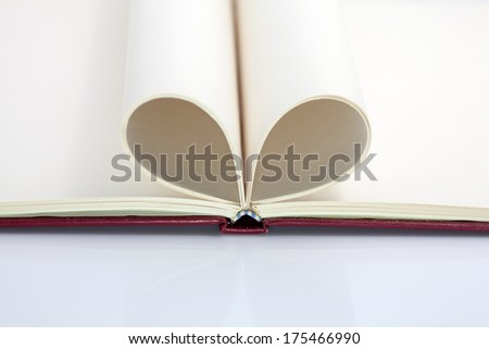 Blank opened notebook with sheets folded in form of a heart