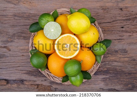 Mix of fresh citrus fruits in basket on wood