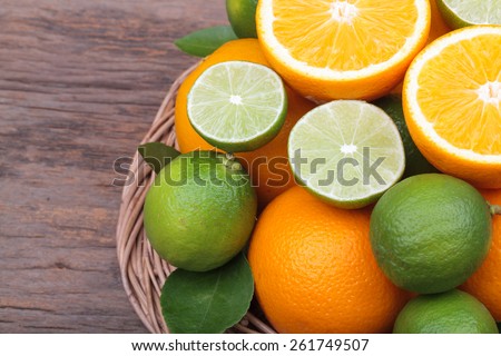 Mix of fresh citrus fruits in basket on wood