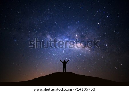 Landscape with milky way galxy, Night sky with stars and silhouette of happy man standing on high moutain