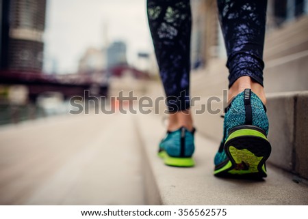 woman athlete feet and shoes while running in the city