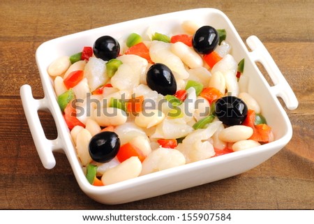 Beans salad with shredded salt cod, tomatoes, bell peppers, onions and black olives. Traditional empedrat typical from Catalonia, Spain
