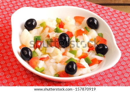 Cod salad with shredded salt cod, tomatoes, bell peppers, onions and black olives, a traditional Spanish dish from the region of Catalonia