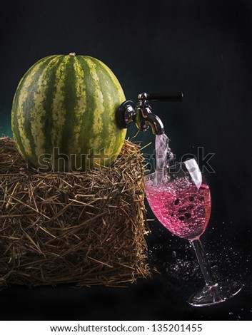 Watermelon with tap pouring juice into a wine glass