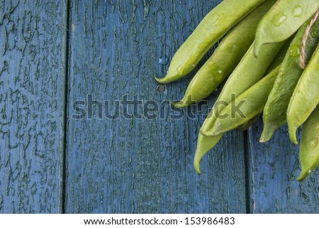 Runner beans ties in a bunch on a wooden board with copy space